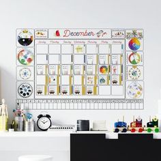 a desk with a calendar on the wall next to a chair and other office supplies