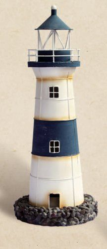 a white and blue lighthouse sitting on top of a sandy beach