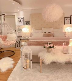 a bedroom decorated in pink and white with hanging lights, fur rugs, chandelier