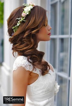 a woman with long hair wearing a white dress and flower in her hair is looking out the window