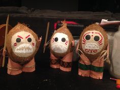 three coconuts with faces painted on them are sitting next to other decorations and tools