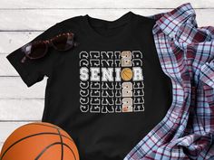 a black shirt with the words senior senior and basketball on it next to some sunglasses