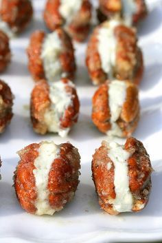 several meatballs covered in cheese and sauce on a white plate