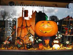 a window display with pumpkins and other halloween decorations