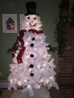 a white christmas tree decorated with lights and a snowman