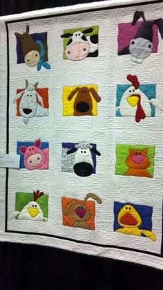 a quilted wall hanging with farm animals on it