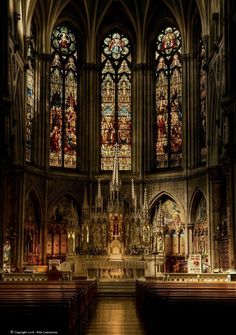 the inside of a church with pews and stained glass windows