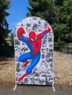 a cardboard cut out of the spider man is on display in front of some trees