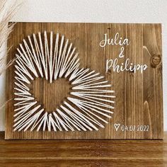 a wooden sign that says julia and phillip on it with white sticks in the shape of a heart