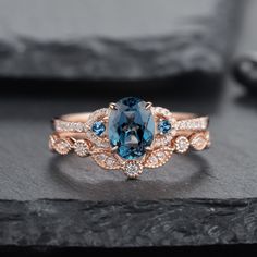 a blue and white diamond ring sitting on top of a stone