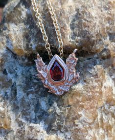 A 3D printed pendant based on the Goron's ruby from The Legend of Zelda: Ocarina of Time. The pendant is set with a 10x7mm ruby red cubic zirconia. Pictured pendant is printed in 14k rose gold plated. 3d Printed Pendant, Dragons Breath Opal, Zelda Ocarina Of Time, Picture Pendant, Ocarina Of Time, Ruby Pendant, Emerald Pendant, The Legend Of Zelda, Ruby Red