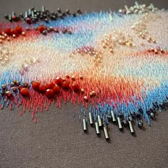 beads and pins are laid out on a piece of fabric that has been stitched together