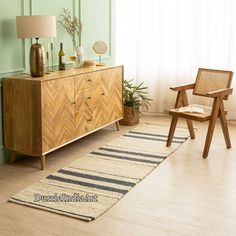 a room with a rug, chair and sideboard