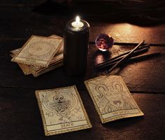 a candle and some cards on a table