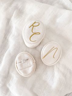 three buttons with the letter e on them sitting on a white cloth covered tablecloth