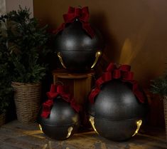 three black vases with red bows on them