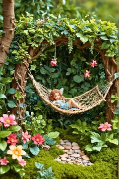 a fairy garden with a hammock and flowers