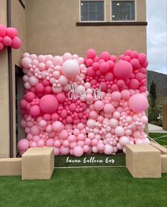 a large balloon wall with pink and white balloons on the front of a house in arizona