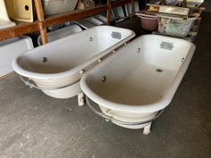 two white bath tubs sitting next to each other in a room filled with furniture