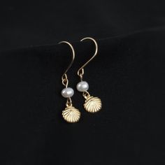 Who doesn't love pearls and seashells? These earrings combine the best of both worlds. You'll love the tiny shell charm and delicate freshwater pearl. A perfect gift for ocean lovers!   ABOUT: * Materials: 14k gold filled wire * Beads: real freshwater pearls and gold filled charm (one-sided, 7mm) * Earring wires: 22 gauge (.64mm) * Lightweight design * Sizing Details: (earring box is 2x3 inches for size reference) * Total Length: 1.25 in. (3cm) * Width: .25 in. (.5cm) SHOP OUR BRAND > https://ro Pearl Drop Shell As A Gift, 14k Gold Shell Jewelry For Gifts, Elegant Pearl Charm Earrings With Shell, Delicate Nickel-free Pearl Jewelry, 14k Gold Filled Shell Shaped Jewelry Gift, Ocean-inspired Pearl Drop Earrings As A Gift, Elegant Pearl Shell With Pearl Drop, 14k Gold Pearl Earrings With Pearl Charm As Gift, Elegant Pearl White Shell With Pearl Charm