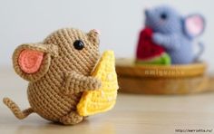 two small crocheted mice sitting next to each other on top of a table