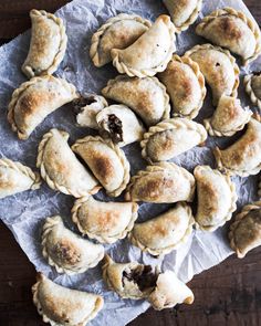 several pastries on a piece of wax paper next to some chocolate chippy cookies