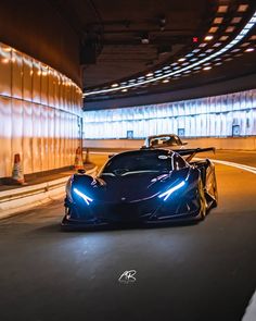 a blue sports car driving through a tunnel