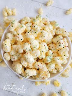 a white bowl filled with popcorn covered in sprinkles on top of a table