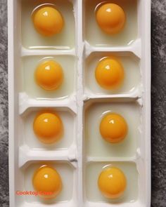 four eggs are in an egg tray on the counter, and one is broken into eight