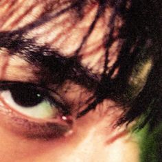 an extreme close up shot of the eye of a man with green eyeshadow