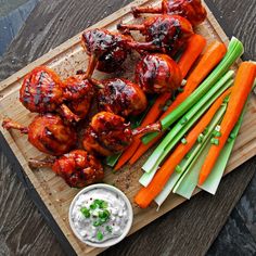 chicken wings with carrots and celery on a cutting board next to dip