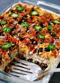 a large casserole with lots of toppings and a fork in the dish