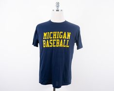 "Vintage wolverines baseball shirt in fairly good condition, area of discoloration at bottom of shirt Made in U.S.A. Size: Tagged L, measures closest to a modern day M (please see measurements) Measurements taken with garment laid flat. Shoulder: 18.25\" Chest: 20.5\" Length: 26\" Sleeve: 8\" Material: 50% Cotton 50% Polyester Label: Jerzees Please message me with questions or for additional photos." Collegiate Cotton Baseball Jersey For Fans, Crew Neck Baseball Fan Jersey, Crew Neck Baseball Jersey For Fans, Cotton Baseball Jersey With Team Logo, Cotton Baseball Jersey For Fans, Collegiate Cotton Baseball Jersey With Crew Neck, Collegiate Short Sleeve Cotton Baseball Jersey, Fan Apparel Crew Neck Baseball Jersey, Collegiate Cotton Short Sleeve Baseball Jersey