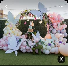 a bunch of balloons that are in the grass