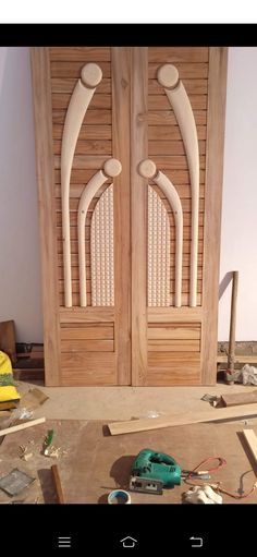 two wooden doors in the process of being built with woodworking tools and construction materials