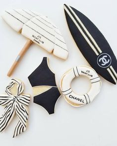 cookies decorated like surfboards and life preservers are arranged on a white table top