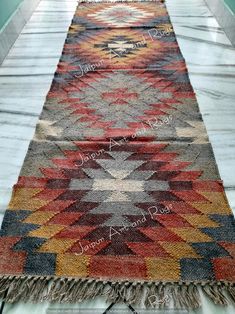 a multicolored rug with fringes on the floor