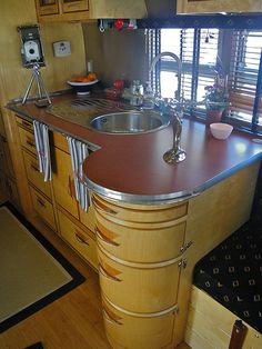 a kitchen area with sink, stove and cabinets in it's own houseboat