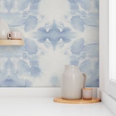 a blue and white painted wall with vases on the shelf in front of it