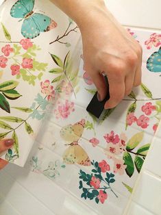 a person is using a stamper on a flowered wallpaper with butterflies and flowers