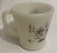 a white coffee cup with brown designs on it