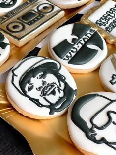 decorated cookies with black and white frosting on gold platter, including one featuring an image of abraham lincoln