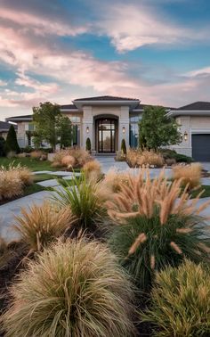 a large house with lots of grass in front of it and bushes around the yard