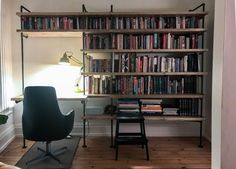 a room with a chair, desk and bookshelf