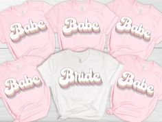 six pink shirts with the word babe on them, all in different colors and sizes