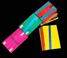 four brightly colored pieces of paper with writing on them and one folded up in the shape of a rectangle