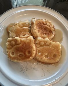 three chinese pancakes on a white plate with syrup