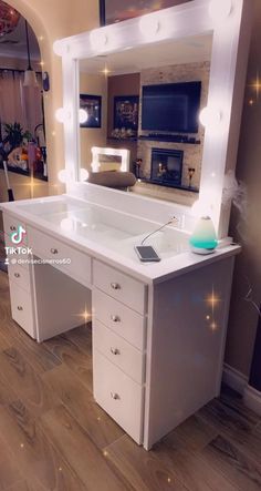 a white vanity with lights on it in front of a mirror