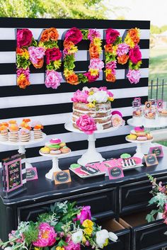 a decorated dessert table with flowers on it