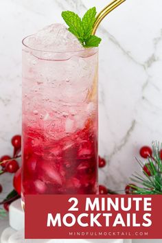 a red drink with ice and mint garnish on the rim in front of a marble background